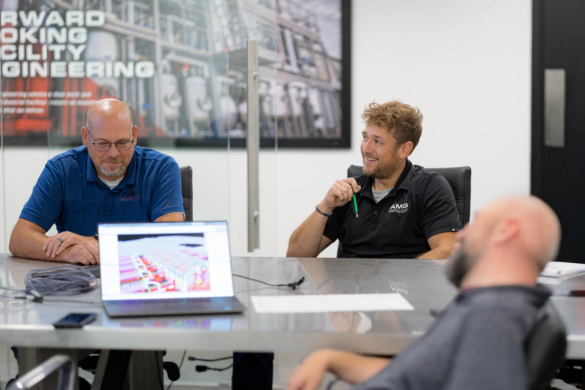 AMG's engineering and design team members in a conference room discussing a client project.